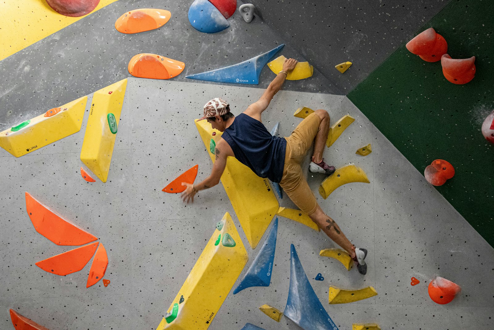 Man climbing an indoor bouldering wall at a climbing gym