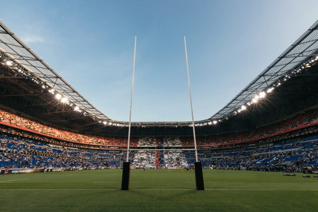 Rugby goal posts on a green pitch inside a large crowded stadium in France