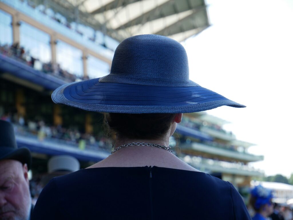 Woman in a blue hat at the races, a typical Royal Ascot look