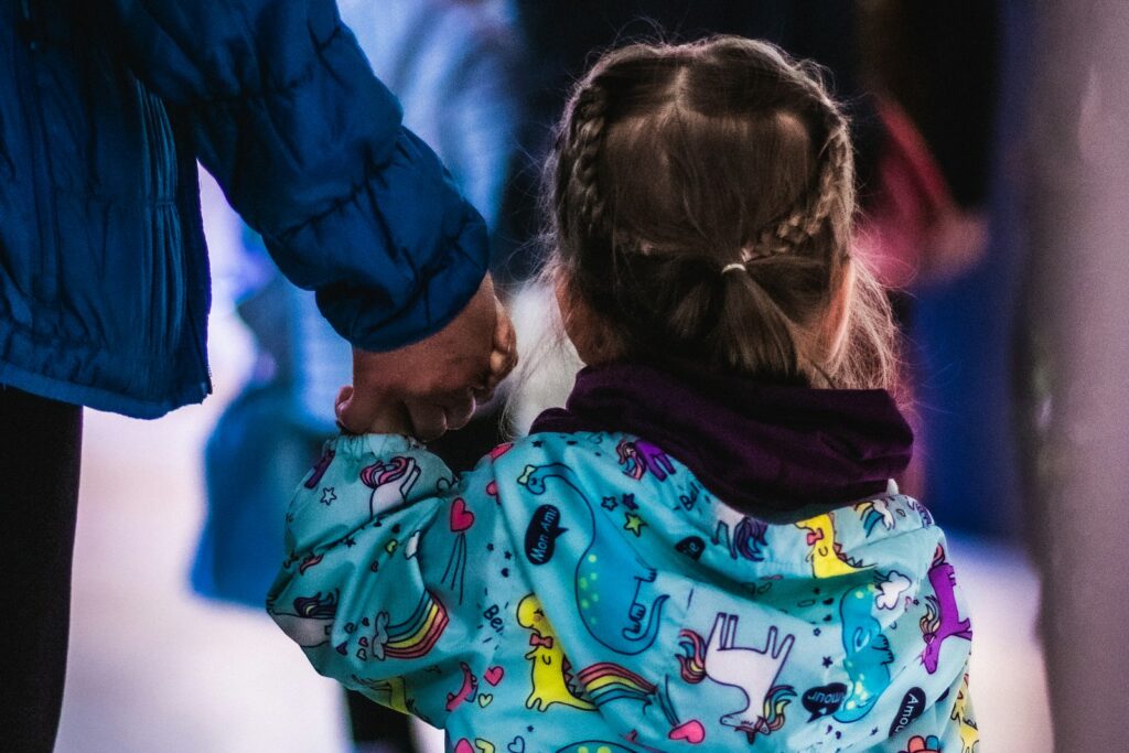 Little girl holding the hand of an adult, reflecting the trust a fostered child needs