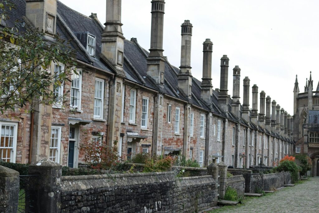 Row of historic brick houses with tall chimneys, typical of older homes with ageing drains